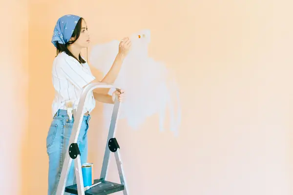 Interior painting in Birmingham: painter on a stepladder rolling a wall